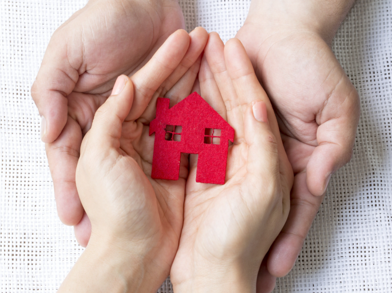 Hands holding a tiny house