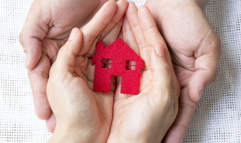 Hands holding a tiny house